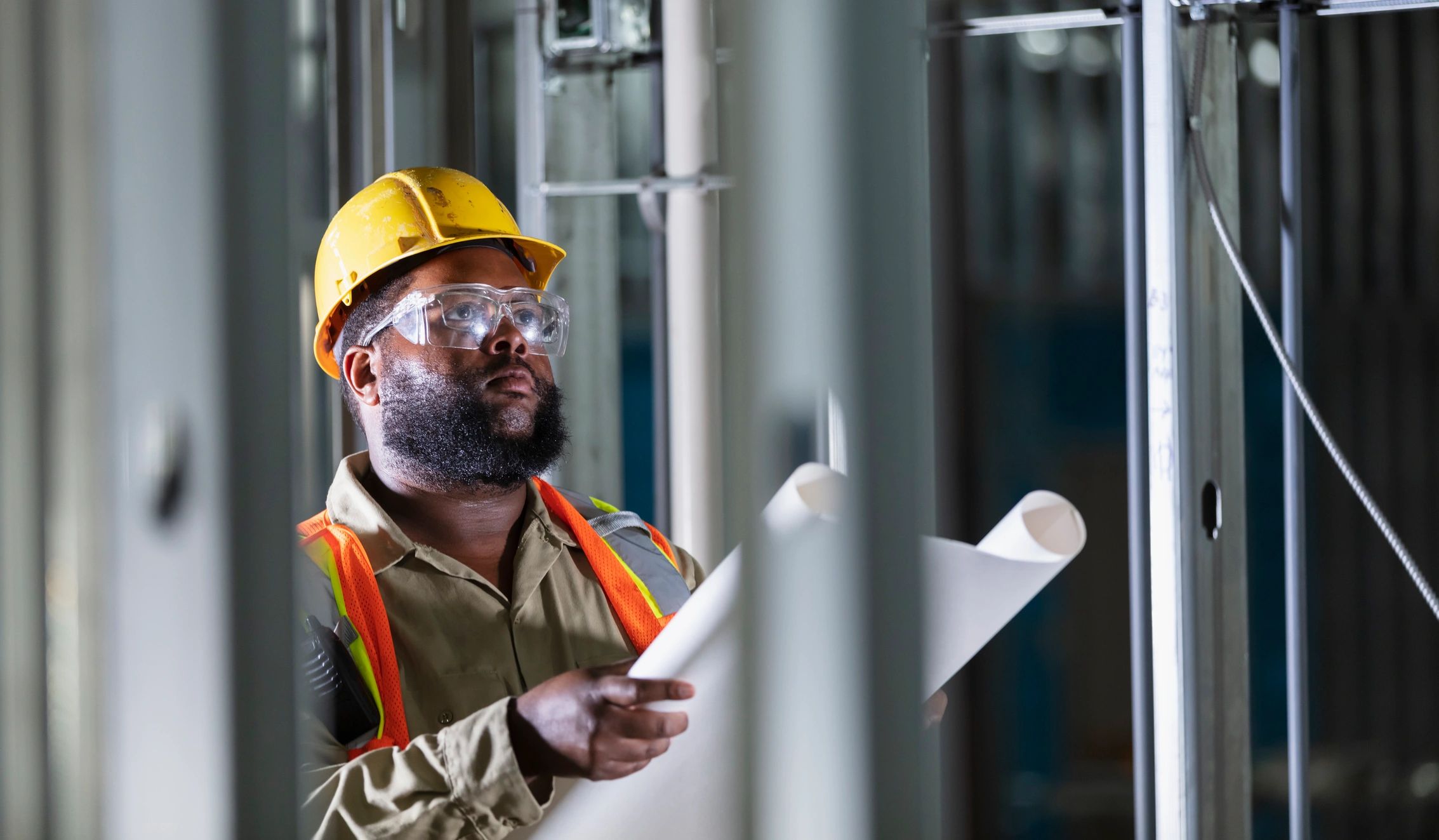 Construction professional holding blueprints on site