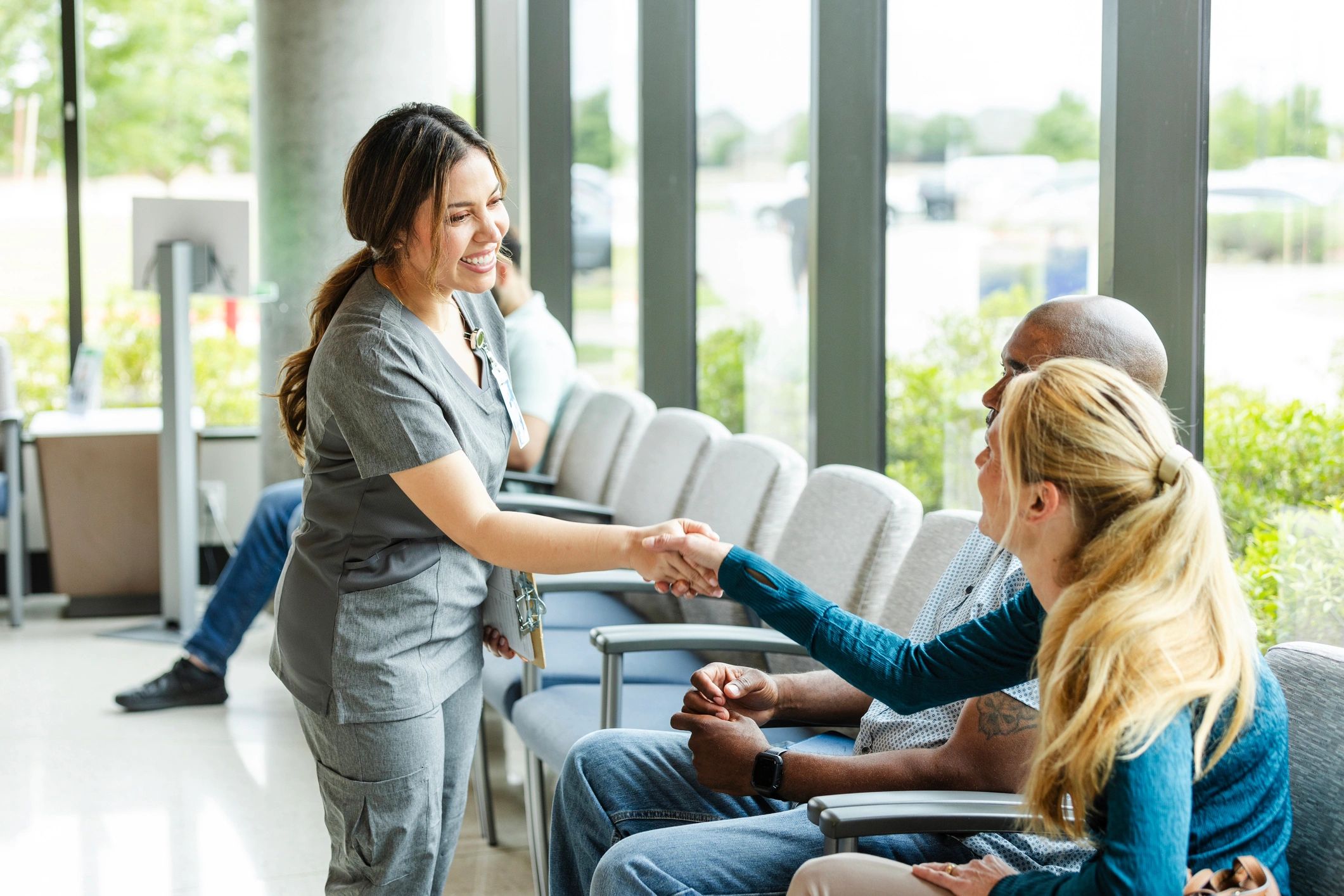 Handshake between a nurse and a client in a hospital setting