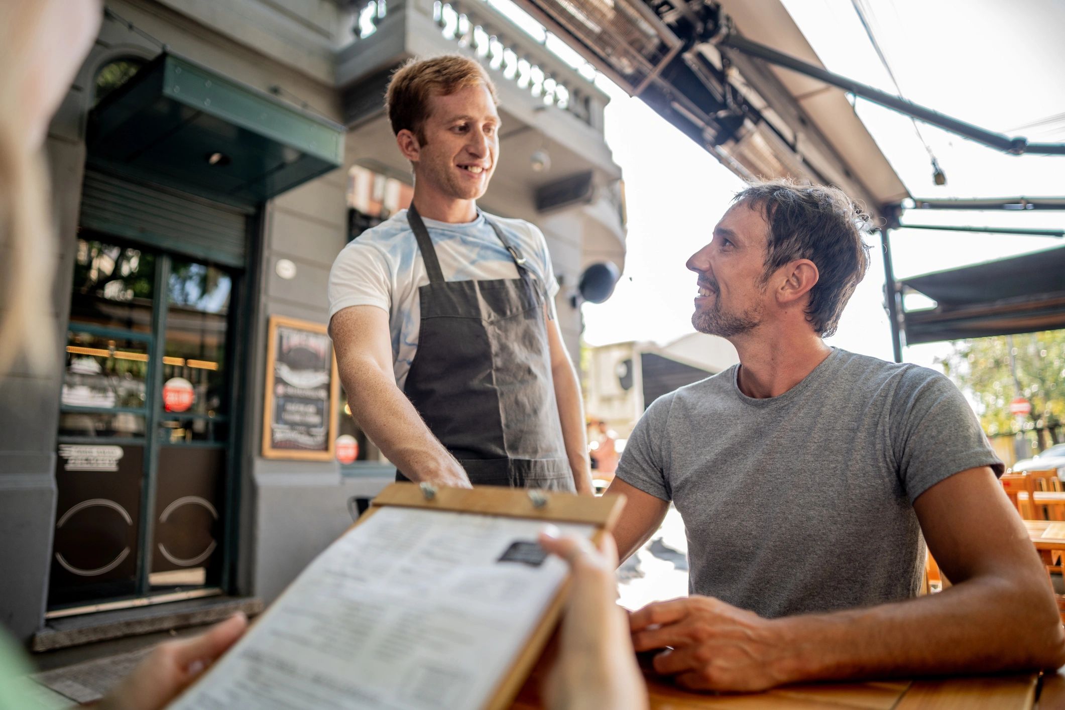 Waiter speaking with customers at an outdoor cafe