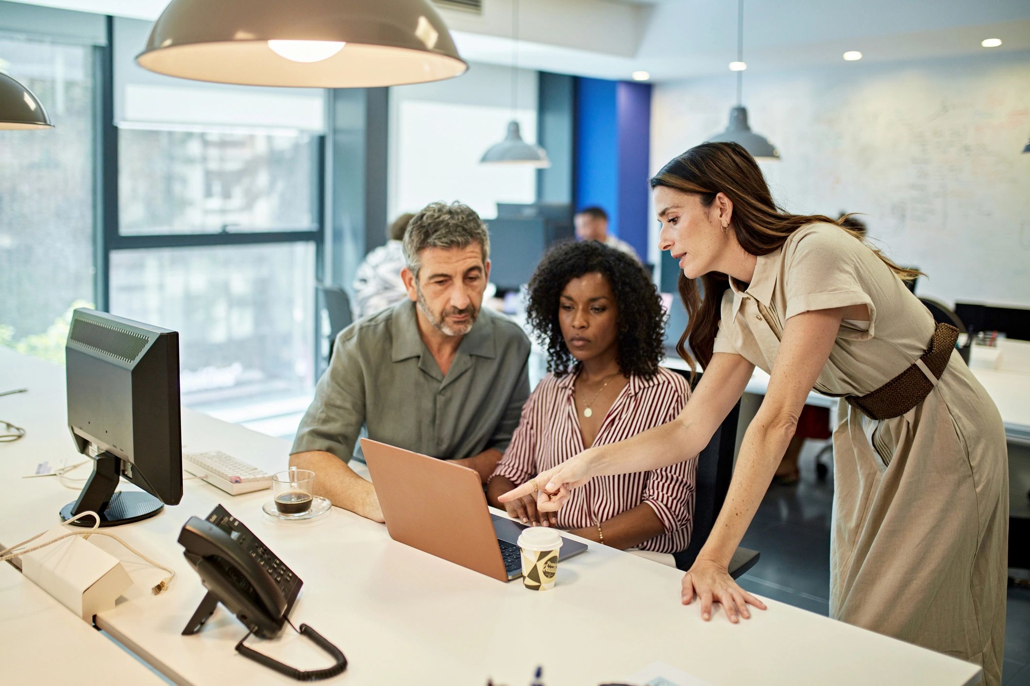 Office team reviewing information on a laptop at a workstation